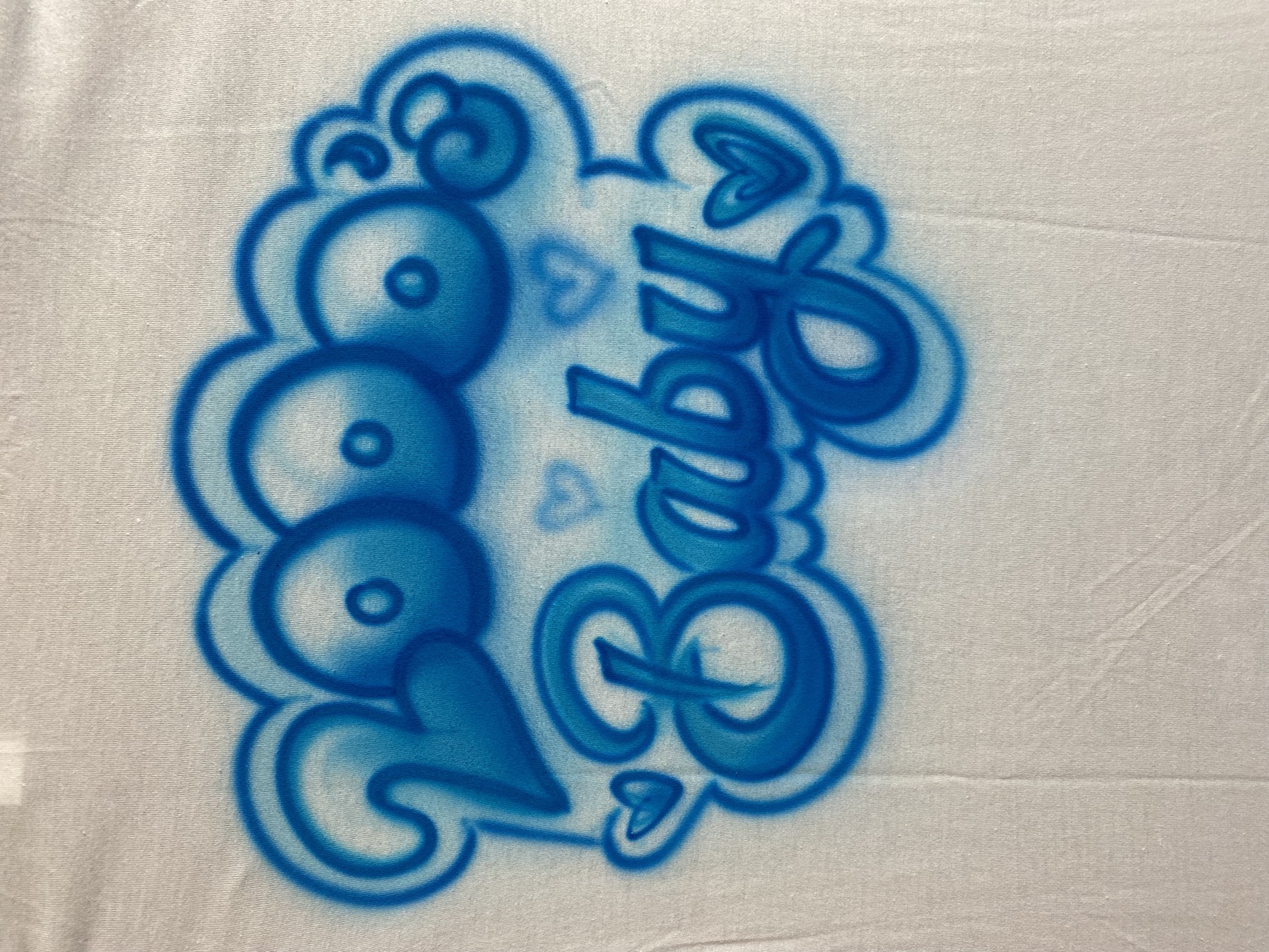 Airbrushed bubble-script name on a tee by Tina Cozart