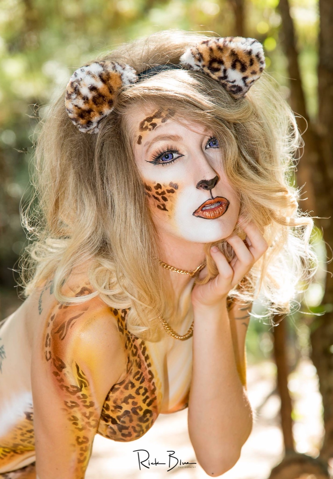 A model in leopard-spot face and body paint with leopard ears
