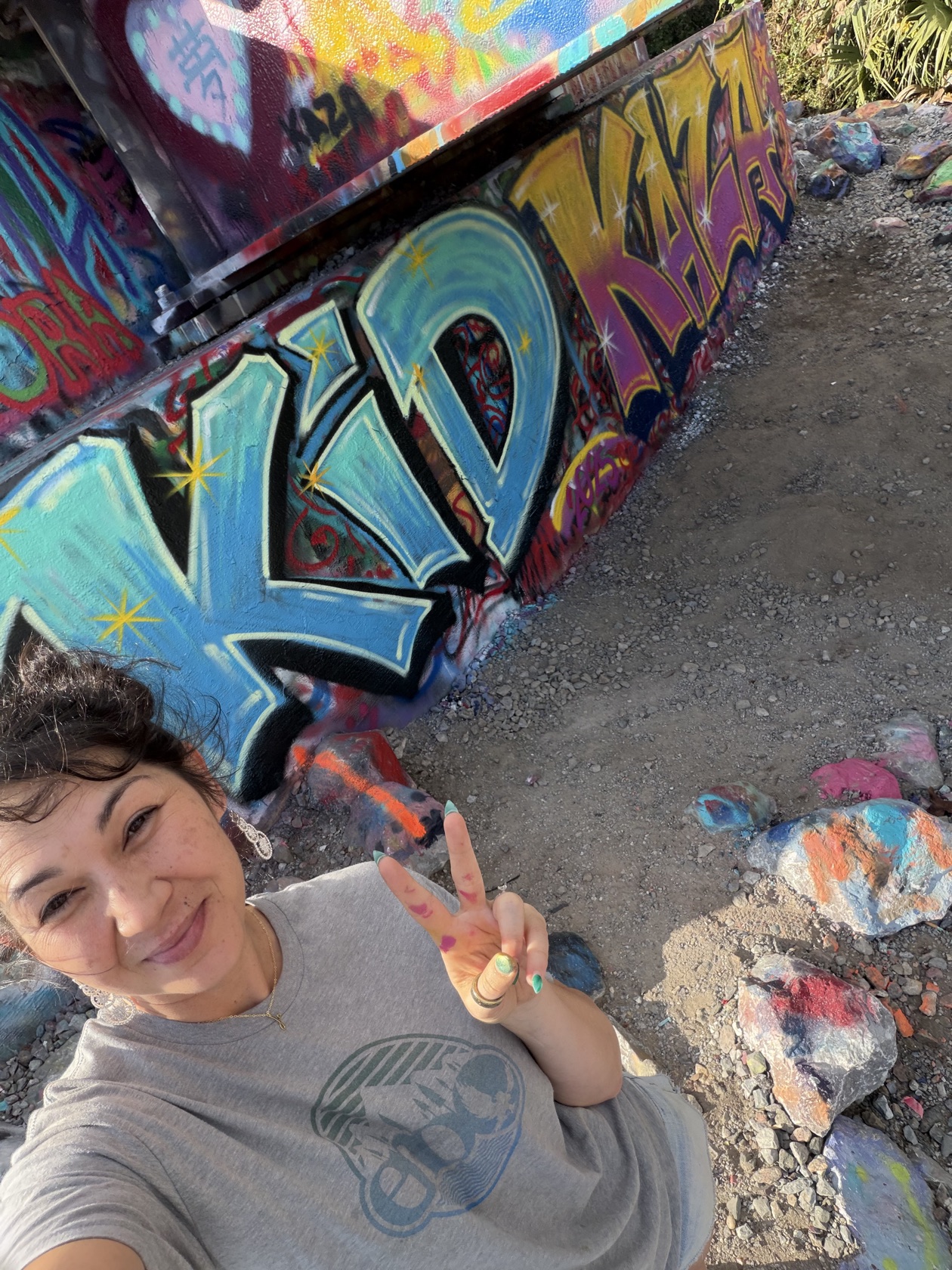Tina Cozart on site at the KID KAZA memorial wall she hand-painted