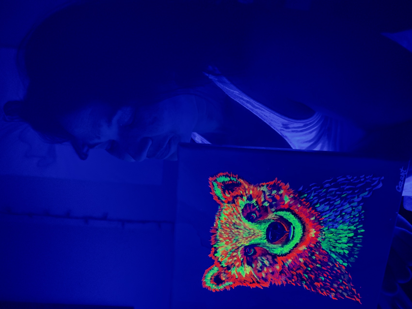 A glowing UV-reactive design lit under black light, by Tina Cozart